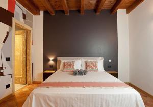 - une chambre dotée d'un grand lit blanc avec deux chaussures dans l'établissement ANNAMA Coliving, à Brescia