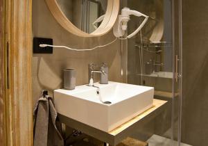 La salle de bains est pourvue d'un lavabo blanc et d'un miroir. dans l'établissement ANNAMA Coliving, à Brescia