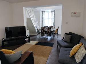 a living room with a couch and a tv and a table at Bright Spacious Twin Room, next to Underground Station in Abbey Wood