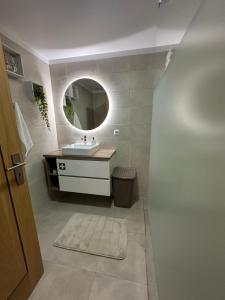 een badkamer met een wastafel en een spiegel bij Lido View Holiday Apartment in Funchal