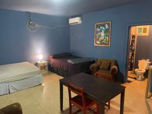 a room with a bedroom with a bed and a table at Airport Inn Roatan in Coxen Hole