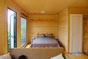 sypialnia w drewnianym domku z łóżkiem w obiekcie Kottage anania w mieście Batumi