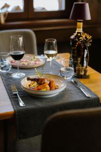 a table with a plate of food and glasses of wine at Alpine Hotel Perren in Zermatt