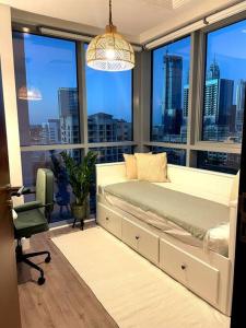 a bedroom with a bed and a desk and a window at Lakeside Bliss Home in Dubai