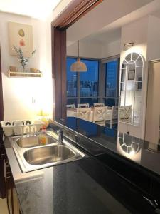 a kitchen with a sink and a large mirror at Lakeside Bliss Home in Dubai