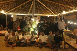 a group of people posing for a picture under a tent at Revibe Beach Hostel Gokarna in Gokarna