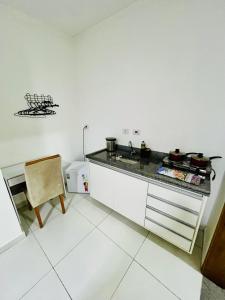 a white kitchen with a counter and a sink at Flat Gru in Guarulhos