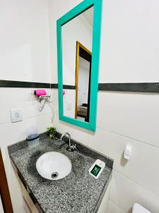 a bathroom with a sink and a mirror at Flat Gru in Guarulhos