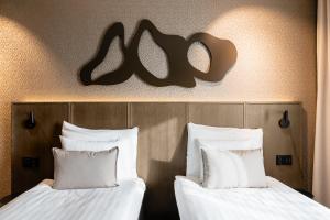 two beds in a hotel room with white pillows at Original Sokos Hotel Puijonsarvi in Kuopio