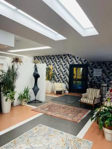 una gran sala de estar con plantas y una habitación con techo en Green Hotel Motel, en Vergiate