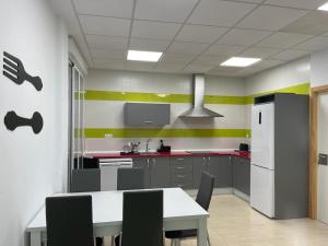 a kitchen with a white table and a refrigerator at La Antigua Editorial in Pozuelo de Zarzón