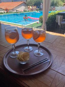Drie glazen sinaasappelsap en chips op een dienblad. bij View Villas in Chersonissos