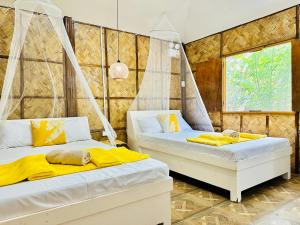 2 camas en una habitación con sábanas amarillas en Dreamland Paradise Resort en Batangas