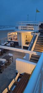 - un balcon sur un bateau de croisière avec des tables et des bancs dans l'établissement Duplex avec 3 chambres à 30m de la plage, à Merlimont
