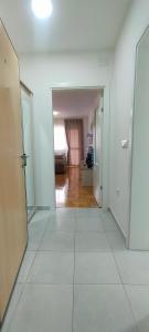 an empty room with a white floor and a bedroom at Apartman Ema in Valjevo
