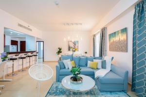 a living room with a blue couch and a table at Maison Privee - Premium Apt in the Heart of JBR Beach, Dubai in Dubai