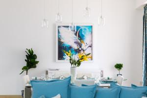 uma sala de jantar com cadeiras azuis e um quadro na parede em Maison Privee - Premium Apt in the Heart of JBR Beach, Dubai em Dubai
