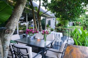 a table and chairs with flowers on a patio at 90 9 Pool Villa Chiang Mai in Ban Pa Ngae