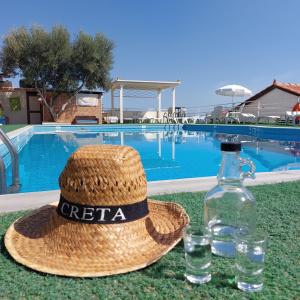 słomiany kapelusz i butelka wody przy basenie w obiekcie View Villas w mieście Hersonissos