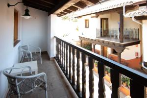 einen Balkon eines Hauses mit Stühlen und einem Tisch in der Unterkunft Hotel Rural Abadía de Yuste in Cuacos de Yuste