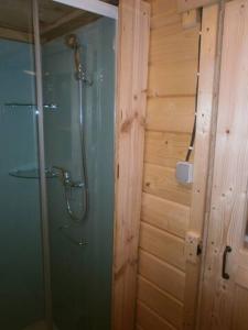 La salle de bains est pourvue d'une douche et d'un mur en bois. dans l'établissement camping Manex, à Saint-Pée-sur-Nivelle