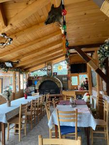 a dining room with tables and chairs and a fireplace at Vila Grand Mitrovac in Mitrovac