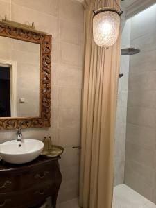 y baño con lavabo y ducha con espejo. en Old Town apartments with charming terrace, en Kaunas