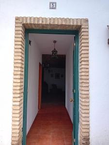 a hallway with a green door leading to a room at Caserío de Vazquez 5 in Castilblanco de los Arroyos