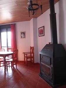 a living room with a stove and a table at Caserío de Vazquez 5 in Castilblanco de los Arroyos