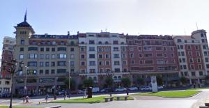 a large building with people walking in front of it at Habitación grande y confortable con baño privado junto a Guggenheim in Bilbao