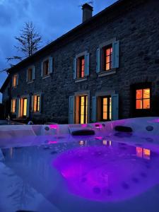 une maison avec des lumières violettes devant elle dans l'établissement Lerefugedetiti, à Buissard