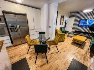 a dining room with a glass table and yellow chairs at East London Townhouse by Harlington in London