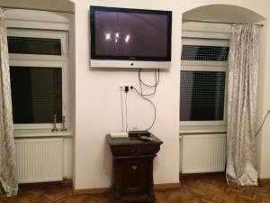 a flat screen tv on a wall with two windows at Apartament Sophie in Sibiu