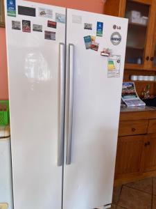a white refrigerator in a kitchen with magnets on it at Hotel San Juan in Coquimbo