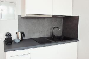 a kitchen with a sink and white cabinets at Hometown-Apartments in Heidelberg