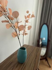 a blue vase with a plant in it on a table at Apartman Tara in Subotica