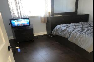 1 dormitorio con 1 cama y TV de pantalla plana en ShayCozyDelux-Room-201 en Pickering