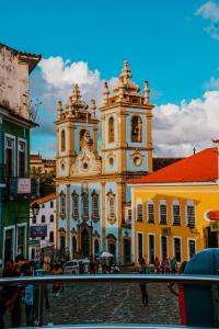 un grand bâtiment avec une tour d'horloge dans une ville dans l'établissement Casarão de época , Stúdios até 6 hóspedes., à Salvador