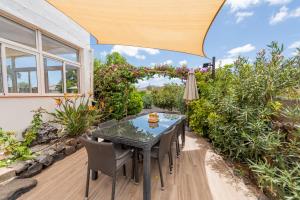 a table and chairs on a patio with a large umbrella at Casa YUKKA villa with heated pool in Lajares