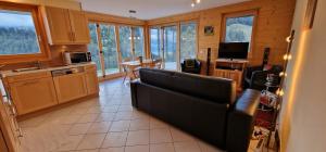 a living room with a couch and a kitchen with windows at Majis 4 in Champoussin +7 photos