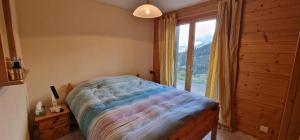 a bedroom with a bed and a large window at Majis 4 in Champoussin