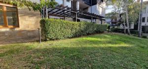 a hedge in front of a building next to a building at Eve Santa Marina Apartments - sea, pools, relax in Sozopol