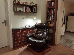 una silla de cuero negro en la sala de estar en FeWo Zum Laacher See en Mendig