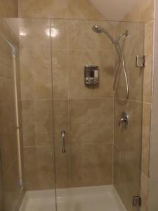 a shower stall with a glass shower door at Inn on the Moraine in Caledon