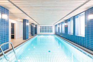a large swimming pool with blue tiles on the walls at Haus Halligblick Whg 20 in Wyk auf Föhr