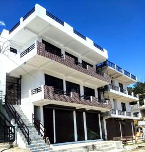 ein weißes Gebäude mit einer Treppe davor in der Unterkunft Tulsi Homestay in Munsyari
