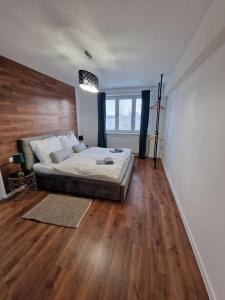um quarto com uma cama e piso em madeira em Luxusný byt, 5 Minút peši do Centra em Košice