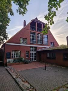a large red brick building with windows and a driveway at Gästehaus Lichtblick in Herrenhof