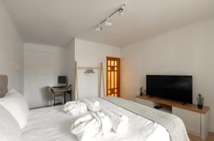 a bedroom with a white bed with a flat screen tv at Modern Traditional apartment in Chişinău
