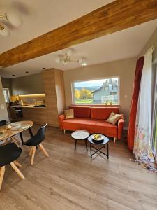 a living room with a red couch and a table at Ostoja Pod Osówką dom Spokój in Sierpnica